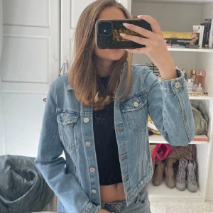 Blå jeansjacka från Zara - Säljer en klassisk blå jeansjacka från Zara i storlek S. Jackan har knappar framtill, två bröstfickor med lock och långa ärmar. Perfekt för dig som vill ha en tidlös och snygg denimlook. Passar till det mesta och är ett måste i garderoben.