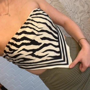 Zebramönstrad tubtopp från Gina Tricot - Säljer en snygg tubtopp från Gina Tricot med svartvitt zebramönster. Toppen är axelbandslös och har en triangelformad front med knyt i ryggen. Materialet är lent och lätt. I storlek xs/s. Fint skick🌸  Kolla gärna in mina andra artiklar också för en bundle-rabatt😊