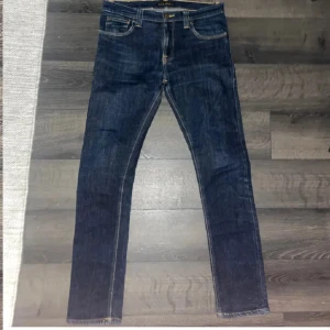 Mörkblå jeans från Nudie Jeans - Snygga mörkblå jeans från Nudie Jeans. Perfekta till vardags och lätta att matcha med olika stilar. Säljer pga av att de ej passa mig. Helt oanvända. Storlek: 31-32. Passform slim fit. Pris kan diskuteras vid snabb affär🤝