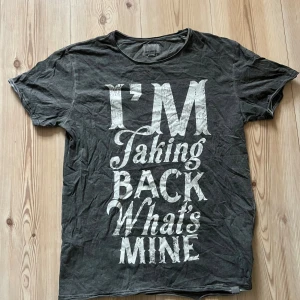 Grå t-shirt Shine Original M - Snygg grå t-shirt från Shine Original i storlek medium med stor vit textprint på framsidan: 'I'M Taking BACK What's MINE'. Klassisk rund hals och korta ärmar, tillverkad i mjuk bomull. Perfekt för dig som gillar statement-plagg.