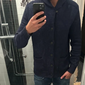 Mörkblå stickad kofta Polo Ralph Lauren - Säljer en mörkblå stickad kofta från Polo Ralph Lauren.Nypris- ca 3500kr. Perfekt att hålla värmen till vintern. Använd fåtal gånger o säljer då jag behöver pengarna. Kan gå ner vid snabb affär!💸