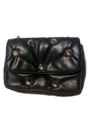 Svart quiltad axelväska med nitar - Snygg svart axelväska i quiltad skinnimitation med guldfärgade kedjedetaljer och coola nitar på locket. Väskan har en bred axelrem och en mindre kedja för extra stilpoäng. Perfekt för dig som vill ha en edgy accessoar till din outfit.