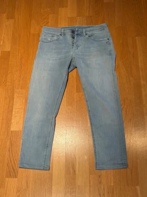 Dondup George 33 slitningar  - Dondup ljusblå med fabriks slitningar. Stl 33 skulle jag säga lappen i jeansen är borta men har mått. Midja 43 cm, längd 92 cm. hör av dig vid mer funderingar eller bilder!