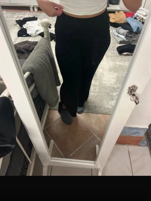 Svarta wide byxor med slits - Säljer ett par svarta ribbade byxor med wide passform och snygg slits vid benslutet. Byxorna har hög midja och är riktigt sköna att ha på sig. Perfekta om du gillar en stilren look med lite extra edge. Materialet känns mjukt och sköna att ha hemma.