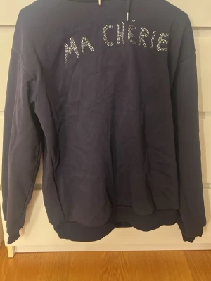 marinblå ma chérie hoddie - jättefin marinblå hoodie med med glitter text över bröstet. andvänd ca 2 gånger och har inga tecken på användning. Storlek 158/164 men funkar för s och xs med!! pris kan alltid diskuteras🤗