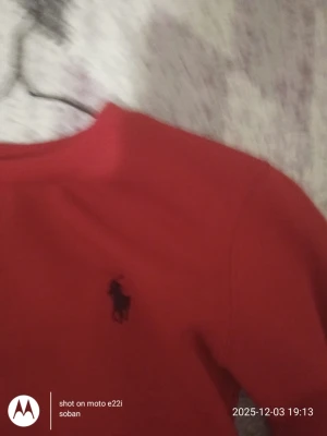 Röd sweatshirt från Polo Ralph Lauren - Säljer en röd sweatshirt från Polo Ralph Lauren med klassisk svart logga broderad på bröstet. Tröjan har rund hals och långa ärmar, perfekt för dig som gillar enkel och stilren design. Materialet känns mjukt och bekvämt mot huden.