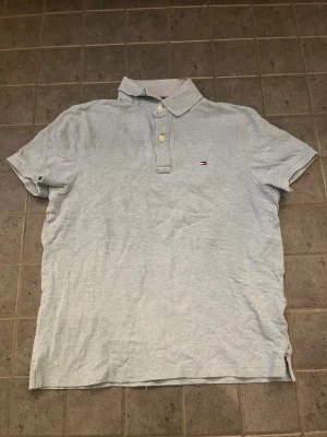 Tommy Hilfiger Piké - Grå Pikée från Tommy Hilfiger. Använd en gång (för test men den passade inte). Den är äkta så du behöver inte fråga (har inte bevis på äkthet eller kvitto men jag fick den i present). Pris: 149kr men kan diskuteras!