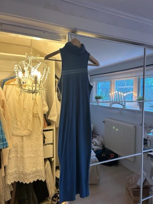 Blå ärmlös långklänning - Säljer en stilren blå, figursydd klänning med polokrage. 