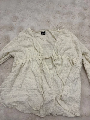 Topp från Gina tricot - Säljer nu min topp från Gina tricot pga ingen användning. Har används ca 2-3 gånger max. Super fin och går att knyta vid brösten som tröja eller så kan man ha den som kofta