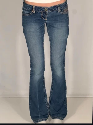  bootcut jeans med  - Snygga blå jeans med bootcut och låg midja. Jeansen har detaljerade broderier på bakfickorna . Verkligen skit coola o snygga. midjemått rakt över :37cm 