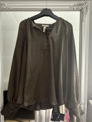 Blus från H&M - Fin blus från H&M med knappar där framme. Den är lite grön aktig men lite oklar vilken färg den är. Den är använd några få gånger så den är i bra skick!