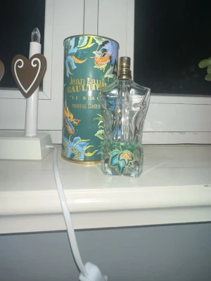 Söker byten Jean Paul Gaultier Le Beau Paradise  - Snygg och unik parfym med tropisk design från Jean Paul Gaultier. Flaskan har coola detaljer och kommer i en färgstark förpackning med Paradise Garden-tema. Perfekt för dig som vill sticka ut med din stil.