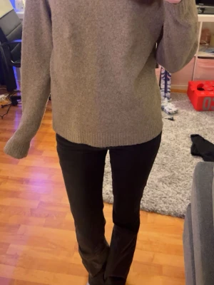 Beige stickad tröja från Vero Moda - Säljer en beige stickad tröja från Vero Moda i storlek M. Tröjan har rund hals, ribbade muddar och lång ärm. Perfekt för dig som gillar enkel och stilren design med mjukt material. Passar dig som vill ha en normal passform och gillar neutrala färger.