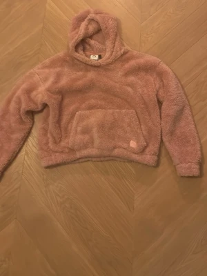 Rosa hoodie - En mjuk rosa hoodie som man kan ha hemma den är jätte skön och ha när man är sjuk.Den är mjuk,fluffig och varm