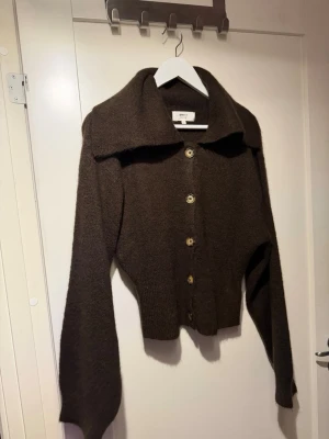 Brun kofta från Gina Tricot i ullmix - Mysig brun kofta från Gina Tricot i ullblandning. Koftan har stora knappar framtill,
