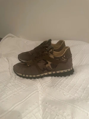 Valentino Rockrunners - Ett par Valentino Garavani Rockrunners i en olivgrön/camoflauge färg. Perfekta inför vintern!❄️ | Storlek: 43 (passar 42 också) | Skick: De är i nästan nyskick, endast använda några gånger då det var i fel storlek (Köpta här på Plick tidigare). Kom gärna med prisförslag eller frågor!🤗