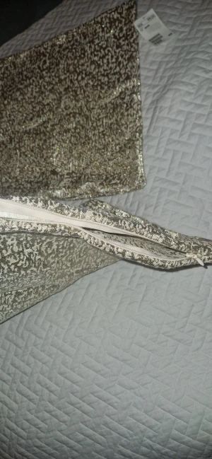 Kuddfodral - Två super fina helt nya kuddfodral med dragkedja i fint guldigt sprickigt mönster, måtten är 40×40. 