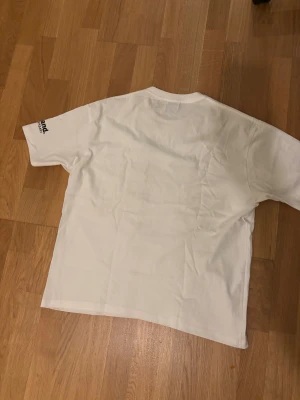 Vit Gallery Dept. Tokyo t-shirt - Vit t-shirt från Gallery Dept. med tryck 'TOKYO, JAPAN' på bröstet och färgglada abstrakta detaljer framtill. Klassisk passform med korta ärmar och rund hals. Materialet är mjuk bomull och trycket har inslag av gult, svart, rosa och blått.