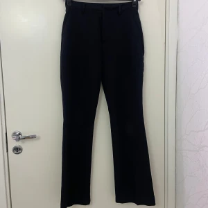 Svarta bootcut kostymbyxor Bik Bok - Svarta kostymbyxor från Bik Bok i storlek 36. Byxorna har bootcut-ben, klassiska fickor fram och passpoalfickor bak. Midjan är normal och materialet känns mjukt och följsamt, perfekt för en clean och stilren look.