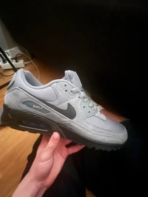 Nike Air Max 90 grå sneakers Storlek 44(Helt nya) använda 1 gång - Nike Air Max 90 sneakers i grått med svart sula och svart swoosh. Skorna har mesh och mockadetaljer, klassisk Air Max-dämpning och snörning. Helt splitternya, använda 1 gång. De är köpta på Nikes hemsida. Sjukt feta å speciellt nu när vintern kommer så passar de bra med en mörkare färg. Pris kan diskuteras vid snabb affär. 