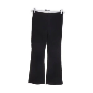 Svarta kostymbyxor från Zara - Svarta kostymbyxor från Zara i storlek 152. Snyggt utsvängda ben. Tillverkade i 76% polyester, 19% viskos och 5% elastan för extra stretch och komfort. Perfekta för en trendig och avslappnad look. Justerbar midja. Lite textilfibrer men annars bra skick. 