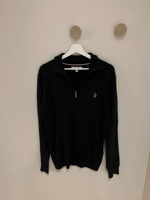 Marinblå half zip tröja U.S. Polo Assn. - Marinblå långärmad tröja från U.S. Polo Assn. i storlek M. Tröjan har en stilren half zip-dragkedja framtill och liten broderad logga på bröstet. Klassisk krage och mjukt material som passar perfekt när du vill ha en clean look.