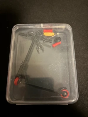 Leksakssparkcyckel  - Säljer en leksakssparkcyckel. Du får med dig skruvmejslar och extra delar. Det finns dock två extra delar som är trasiga. Allt annat är fel fritt. 