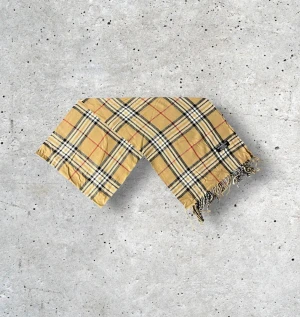 Beige Burberry Scarf - ✨ Klassisk Burberry-halsduk i 100% ull – ikonisk beige ✨ Säljer en tidlös Burberry-halsduk i den klassiska beige färgen med det välkända rutmönstret. Tillverkad i 100% mjuk och värmande ull som både känns lyxig och håller hög kvalitet. En perfekt accessoar som lyfter vilken outfit som helst — lika fin till vardagsjackan som till en elegant kappa.  🧵 Skick: Mycket fint skick, väl omhändertagen 🌟 Känsla: Mjuk, varm och följsam 📦 Frakt: Skickas tryggt inom 24h 📏 Mått: Längd-175cm, Bredd-34cm