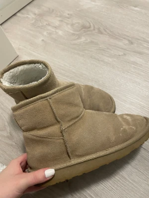 Beiga boots - Mysiga beiga boots från Even&Odd i mocka-look med fluffigt vitt foder på insidan. De har rund tå, platt sula och grovt mönstrad yttersula för extra grepp. Perfekta för kalla dagar när du vill hålla fötterna varma och sköna.