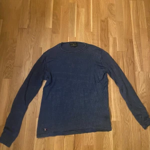 Blå tröja från Morris - Säljer en snygg blå stickad tröja från Morris . Tröjan har rund halsringning och diskret logga nertill. Lite stor i storleken för mig så passar möjligen S/M.