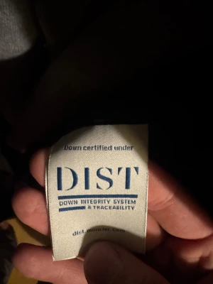 Mörkblå dunjacka från Moncler - Säljer en snygg mörkblå dunjacka från Moncler med klassisk logga på ärmen. Jackan har quiltad design, ståkrage och dragkedja framtill samt vid fickorna. Fylld med vitt gåsdun för extra värme. Perfekt för dig som vill ha en stilren och lätt jacka. Dragkedjan är bytt då förra var förstörd