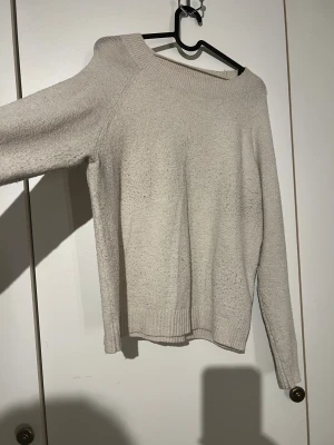 Beige stickad tröja Vero Moda M - Mysig beige stickad tröja från Vero Moda i storlek M. Tröjan har rund hals, långa ärmar och ribbade muddar vid ärmslut och nederkant. Perfekt för lager-på-lager och chill dagar. Enkel och stilren design som funkar till allt.