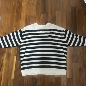 Randig tröja från Zara i bomull - Säljer en vit och marinblå randig tröja från Zara i storlek S. Tröjan har lång ärm, rund hals och är gjord i mjuk bomull. 