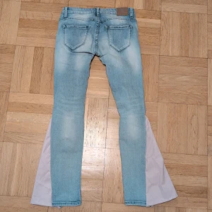 Ljusblå bootcut jeans med slits - Snygga ljusblå jeans med slitningar och trasiga detaljer på benen. Jag har sytt dem till bootcut och mer lågmidjade, kom privat för bild på och mått, skulle passa någon som är 160 eller kortare