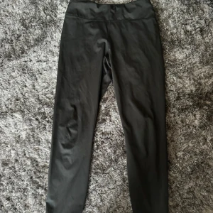 Svarta leggings från Björn Borg - Svarta leggings från Björn Borg med en liten ficka. De har en hög midja och är tillverkade i ett stretchigt syntetmaterial som passar perfekt för träning. Snygg och enkel design utan synliga detaljer eller mönster.