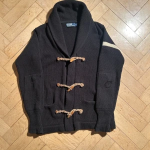 Polo Ralph Lauren duffel cardigan - Distressed detaljer, den är nytt/mycket bra skick. Modellen är 176 och väger 60 för referens. Längd: 70cm, bredd: 50cm. Skriv vid ytterligare frågor eller funderingar🤝