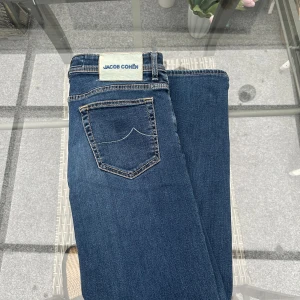 👖 Jacob Cohën jeans – lyxig italiensk denim (strl 34) - Superfina Jacob Cohën jeans, tillverkade i Italien i riktigt hög kvalitet. Klassisk mörkblå denim med snygga detaljer och bekväm passform. De är kända för sin exklusiva känsla och tidlösa stil, perfekt både till vardags och när du vill klä upp dig lite.  💙 Storlek: 34 💙 Färg: Mörkblå 💙 Märke: Jacob Cohën Luxury Denim 💙 Made in Italy 💙 Väldigt fint skick – sparsamt använda  Riktigt lyxiga jeans för dig som gillar kvalitet och italiensk design!