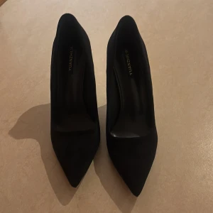 Svarta klackskor  - Svarta mocka pumps med spetsig tå och hög klack. Skorna är helt nya.  