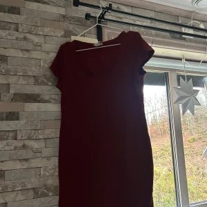 Vinröd kortklänning från H&M - En enkel och snygg vinröd kortklänning från H&M Basic. Klänningen har rund halsringning och korta ärmar, vilket ger en clean och chill vibe. Tillverkad i mjuk bomull som är skön mot huden. Perfekt för dig som gillar minimalistisk stil.