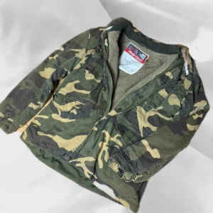 Fodrad Camoflauge Jacka - Fodrad camo jacka som är riktigt fet! Storlek S ! OBS! Men sitter större! – enkel att matcha och skön att bära. Ett stilrent val, noggrant utvalt med omsorg av AM Clothing.  📩 Frågor? Hör gärna av dig! 📲 Följ oss här på Plick för fler uppdateringar. ♻️ Tack för att du handlar mer hållbart med AM Clothing!