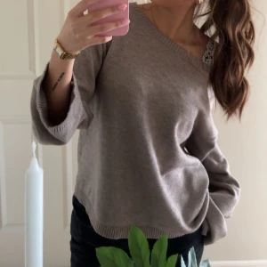 Beige stickad offshoulder-tröja - Säljer en beige stickad tröja med avslappnad passform och offshoulder-skärning. Tröjan har långa ärmar och ribbade muddar vid ärmslut och nederkant. Perfekt för lager-på-lager och chill vibes.