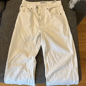 Vita raka jeans från Zara, strl 36 - Snygga vita jeans från Zara i rak modell med klassiska fem fickor och bälteshällor. Byxorna har normal passform och är tillverkade i ett mjukt bomullstyg. Perfekta för en clean och fräsch look.