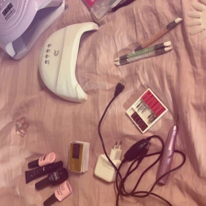 Nagelkit med UV-lampa och elfil - Komplett nagelkit med två UV-lampor, elfil med tillbehör, gelpolish, nageltips (600 st), dekorationer och verktyg. Perfekt för hemmabruk eller nybörjare. Lamporna visar lättare bruksspår men allt är funktionellt.