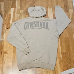 Gymshark hoodie - En beige hoodie från gymshark i storlek M. Endast använd nån gång - tryck på ryggen, perfekt både i och utanför gymmet. Lite halv oversized modell 🫶🏻 - unisex