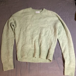 Ljusgrön stickad tröja & Other Stories - Supermjuk ljusgrön stickad tröja från & Other Stories. Tröjan har rund halsringning, ribbade muddar och är långärmad. Perfekt för lager-på-lager och chill dagar. Enkel och stilren design som funkar till allt.