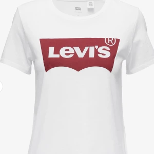 Vit Levi's t-shirt med röd logga - Vit t-shirt från Levi's med klassisk röd logga framtill. T-shirten har rund halsringning och korta ärmar. Original pris: 320 säljer för: 100