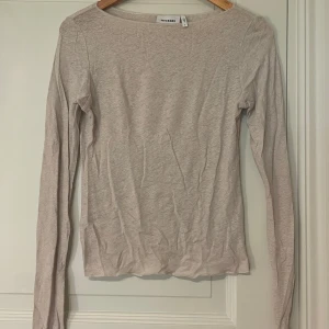 Beige långärmad topp från Weekday - En enkel och stilren beige långärmad topp från Weekday. Toppen har rund halsringning och är tillverkad i mjuk bomullsmix. Påminner om Intimissimi tröjan som är lite genomskinlig! Använd högst 3 gånger, helt nytt skick.