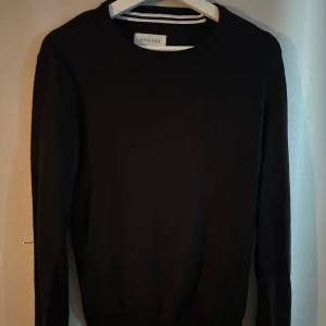 Svart stickad tröja från Pier One - En stilren svart stickad tröja från Pier One med rund halsringning och långa ärmar. Perfekt för lager-på-lager och enkel att matcha med olika outfits. Klassisk passform och mjukt material som känns skönt mot huden.