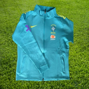 Brasilien träningsjacka - Nyskick/helt oanvänd träningsjacka från det brasilianska landslaget🇧🇷. Denna jacka är i bra kvalité och väldigt bekväm, med den vackra turkosa står den ut bland fotbollsvärldens träningsjackor. Tveka inte att höra av er för fler frågor och bilder!