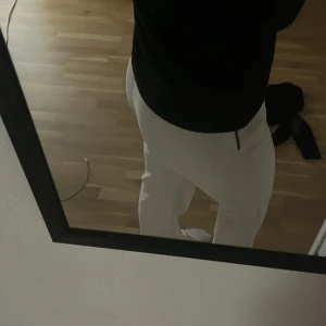 Vita kostymbyxor från Gina Tricot - Säljer ett par snygga vita kostymbyxor från Gina Tricot i storlek 36. Byxorna har rak passform och låg midja, perfekta för en clean och stilren look. Materialet känns mjukt och har en lätt glans. Passar dig som gillar klassiska och fräscha outfits.